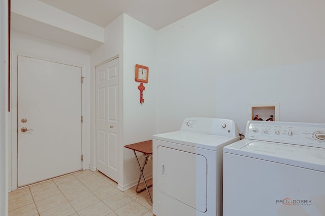 laundry area with laundry area, baseboards, light tile patterned floors, and washer and dryer