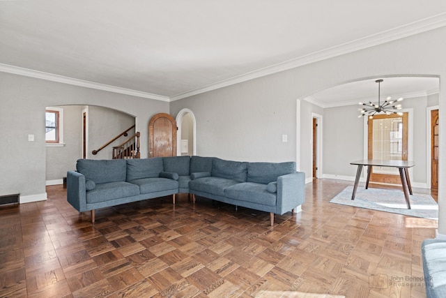 living area with stairway, ornamental molding, arched walkways, baseboards, and a notable chandelier