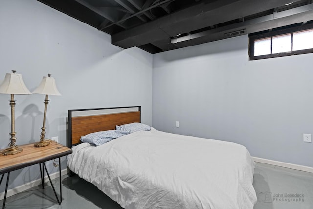 bedroom with finished concrete flooring and baseboards
