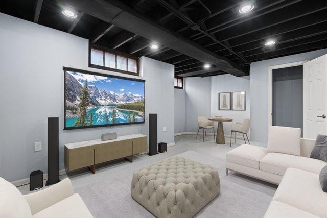 cinema room featuring light colored carpet and baseboards