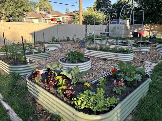 view of yard featuring a vegetable garden and fence private yard