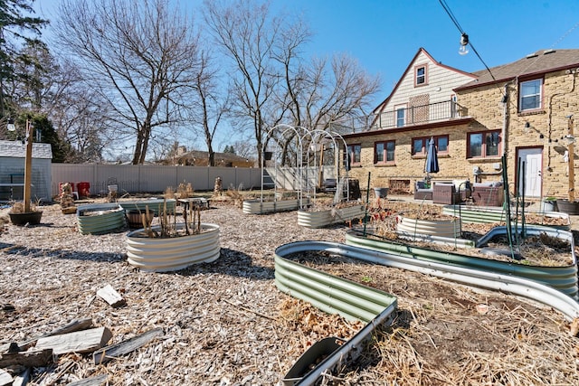 view of yard featuring fence and a vegetable garden