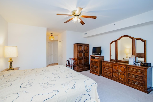 carpeted bedroom with a ceiling fan and visible vents