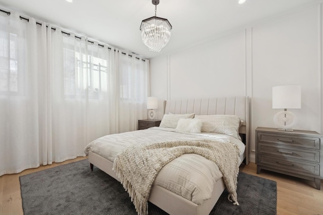 bedroom with a chandelier, light wood finished floors, and recessed lighting