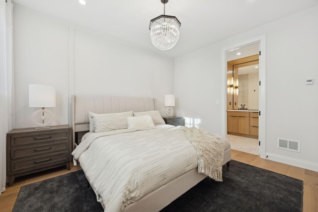 bedroom featuring a chandelier, light wood finished floors, recessed lighting, and baseboards