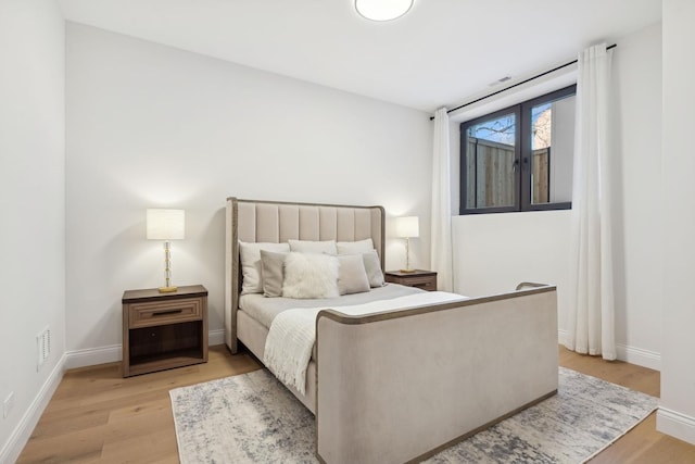 bedroom featuring light wood-style floors and baseboards