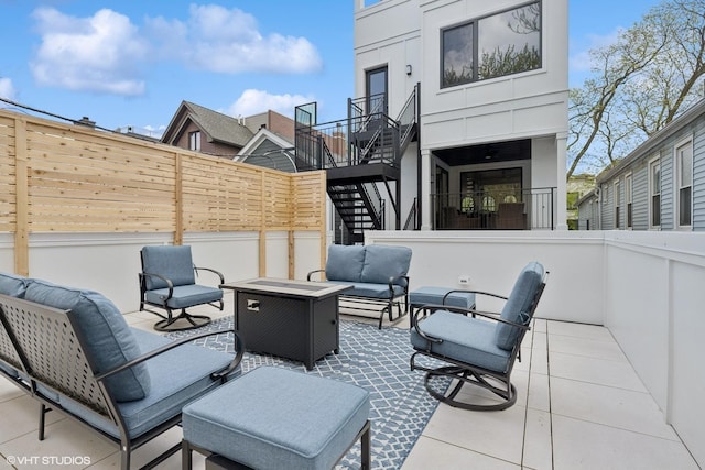view of patio featuring an outdoor living space, stairs, and fence
