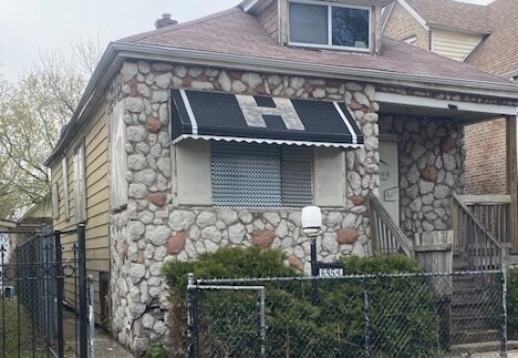 6954 S Honore St, Chicago, IL 60636 - view of property exterior featuring stone siding and fence private yard