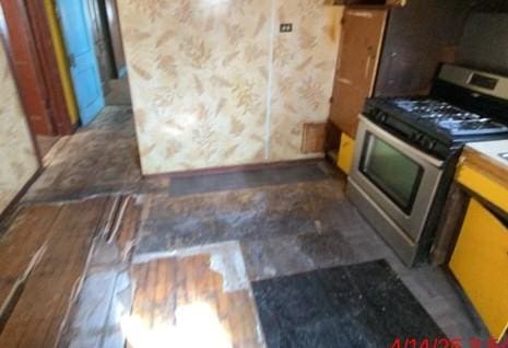 6954 S Honore St, Chicago, IL 60636 - kitchen featuring light countertops, stainless steel gas range oven, a sink, and radiator heating unit