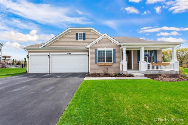 1348 Ritter St, North Aurora, IL 60542 - view of front facade with a porch, a front yard, aphalt driveway, an attached garage, and fence
