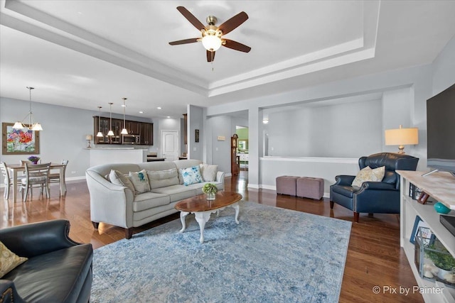1348 Ritter St, North Aurora, IL 60542 - living room with dark wood-style floors, baseboards, a ceiling fan, and a tray ceiling