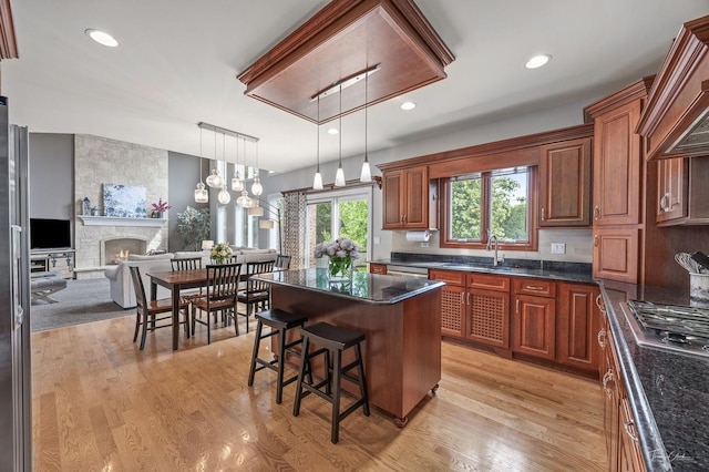 325 Bonnie Brae Ave, Itasca, IL 60143 - kitchen with stainless steel gas stovetop, a fireplace, a kitchen breakfast bar, light wood-type flooring, and recessed lighting