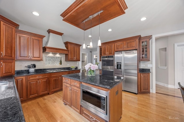 325 Bonnie Brae Ave, Itasca, IL 60143 - kitchen with stainless steel appliances, custom exhaust hood, brown cabinetry, light wood-style flooring, and pendant lighting
