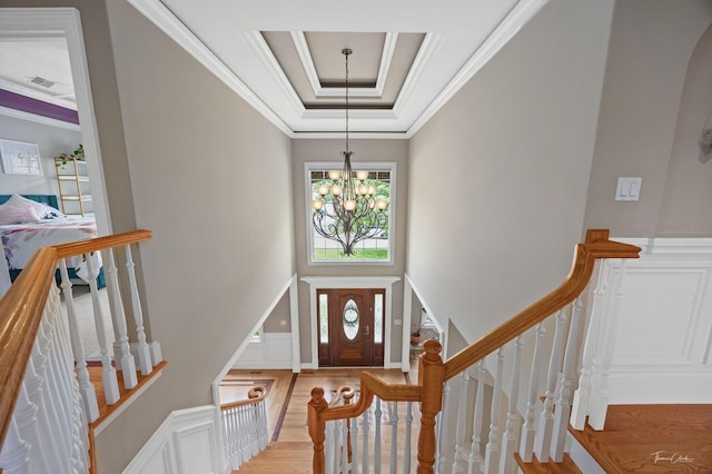 325 Bonnie Brae Ave, Itasca, IL 60143 - entryway with a chandelier, wood finished floors, ornamental molding, a decorative wall, and a raised ceiling