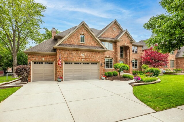 325 Bonnie Brae Ave, Itasca, IL 60143 - view of front of home featuring brick siding, driveway, a chimney, a garage, and a shingled roof
