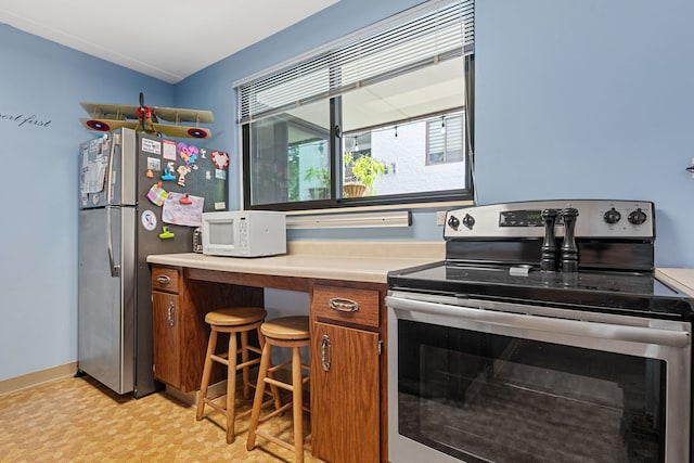 330 W Miner St Unit 1B, Arlington Heights, IL 60005 - kitchen featuring stainless steel appliances, brown cabinetry, light floors, and light countertops