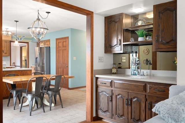 41W838 High Point Ln, Elburn, IL 60119 - kitchen featuring stainless steel fridge, light countertops, a sink, open shelves, and hanging light fixtures