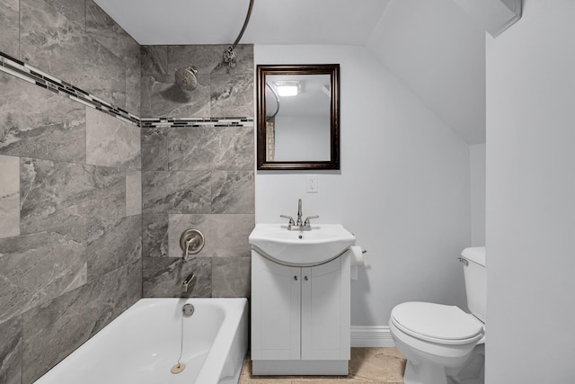 bathroom with toilet, vanity,  shower combination, and baseboards