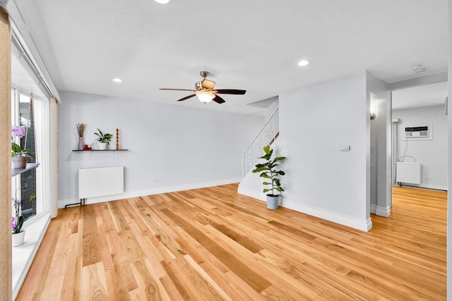 unfurnished living room featuring a ceiling fan, wood finished floors, recessed lighting, and radiator