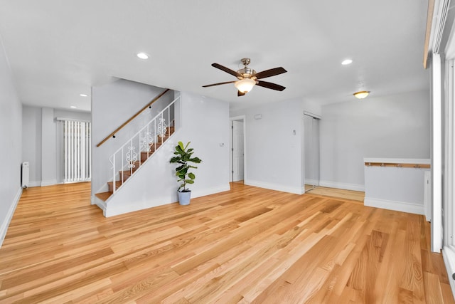 unfurnished living room with radiator, stairway, ceiling fan, and recessed lighting