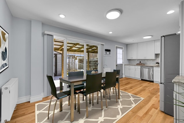 dining space with baseboards, recessed lighting, light wood-style floors, and radiator