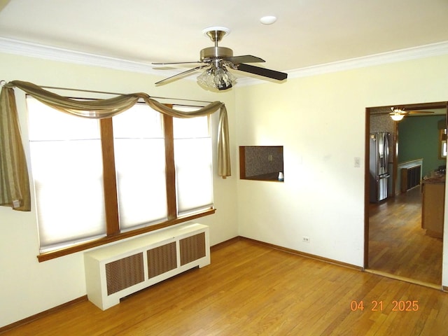 5837 N Navarre Ave, Chicago, IL 60631 - unfurnished room featuring radiator heating unit, crown molding, a ceiling fan, wood finished floors, and baseboards