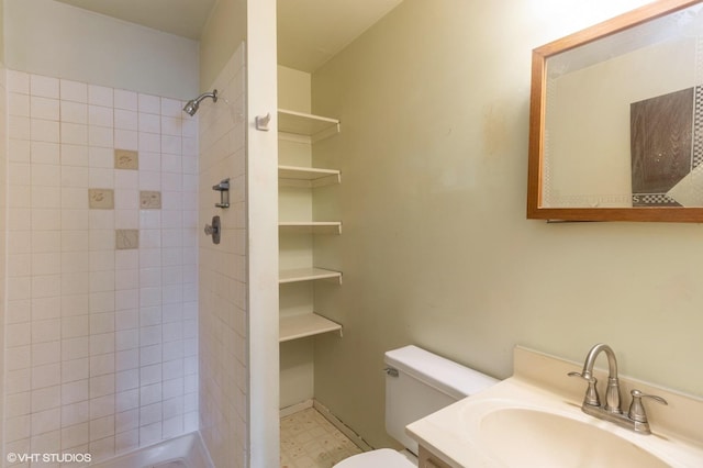 bathroom with toilet, tile patterned floors, tiled shower, and vanity