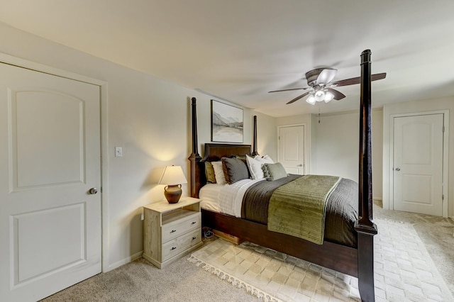 bedroom with light colored carpet, ceiling fan, and baseboards