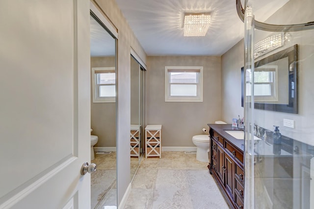 full bathroom featuring a chandelier, baseboards, toilet, and vanity