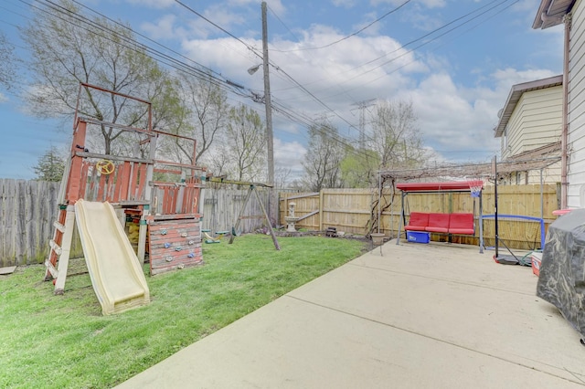view of yard with a patio area, a fenced backyard, and a playground