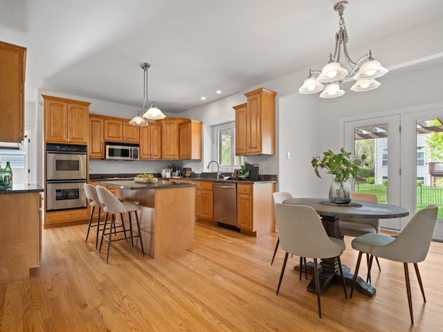 3035 Rollingridge Rd, Naperville, IL 60564 - kitchen featuring dark countertops, appliances with stainless steel finishes, a kitchen breakfast bar, a center island, and light wood-type flooring