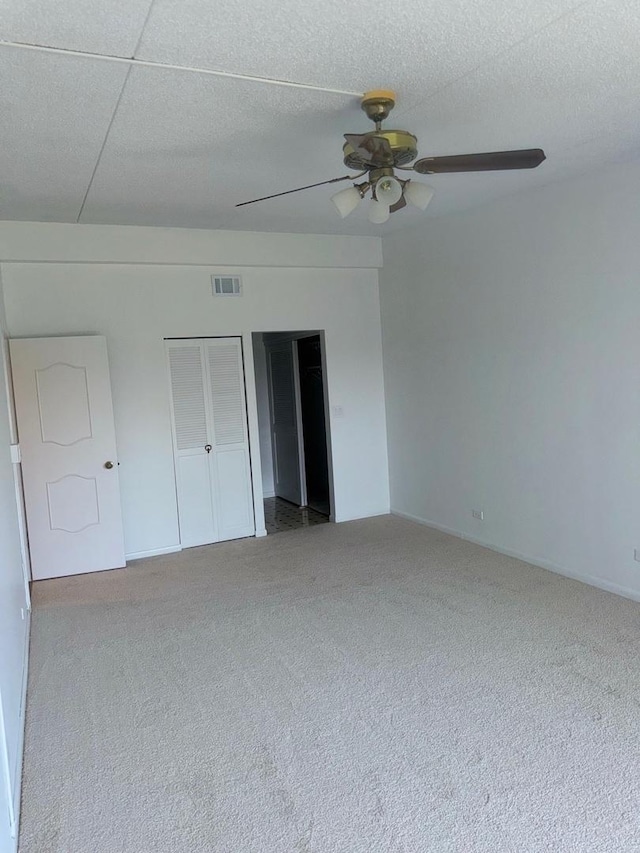 unfurnished bedroom with carpet flooring, a ceiling fan, and baseboards