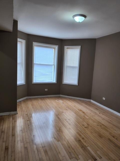 empty room with hardwood / wood-style floors and baseboards