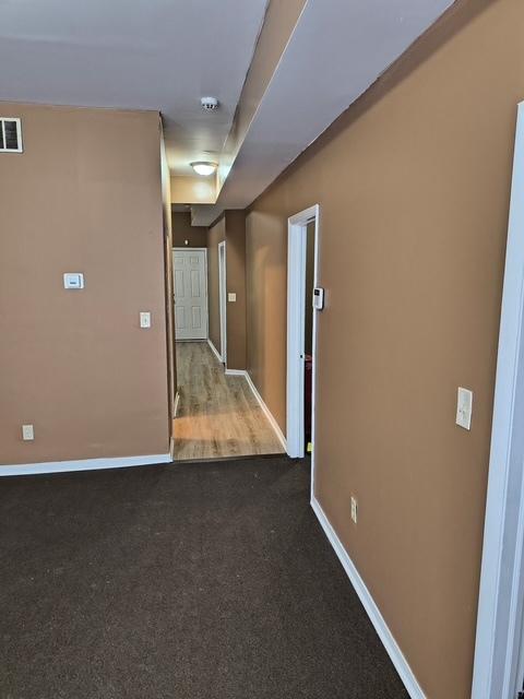spare room featuring baseboards, visible vents, and carpet