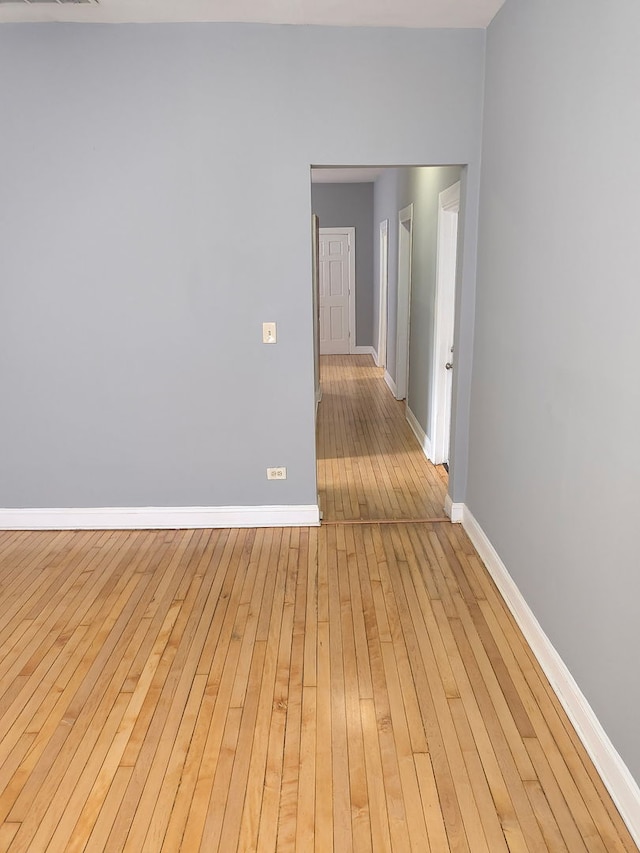 unfurnished room featuring baseboards and wood-type flooring