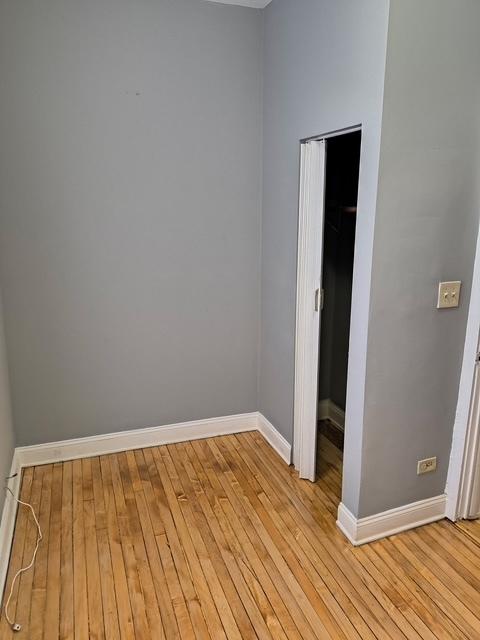 unfurnished bedroom with a closet, light wood finished floors, and baseboards
