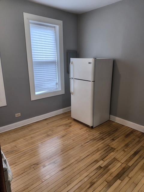 kitchen with baseboards, freestanding refrigerator, and light wood-style floors