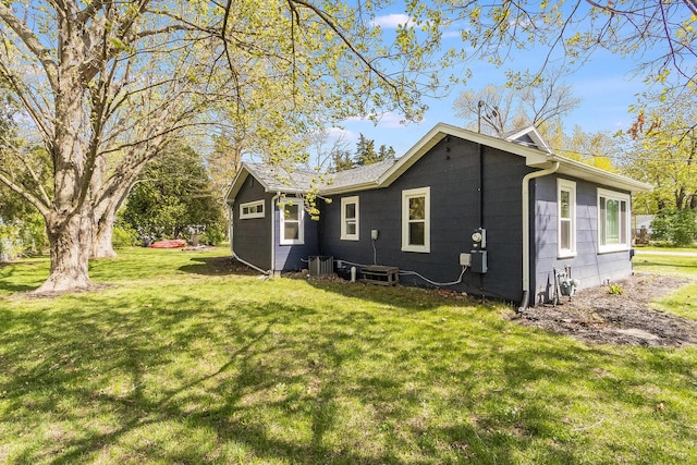 rear view of house featuring a yard and central AC