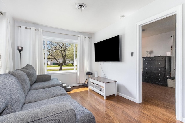living area featuring baseboards and wood finished floors