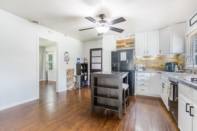 kitchen featuring a sink, dishwashing machine, decorative backsplash, and white cabinets