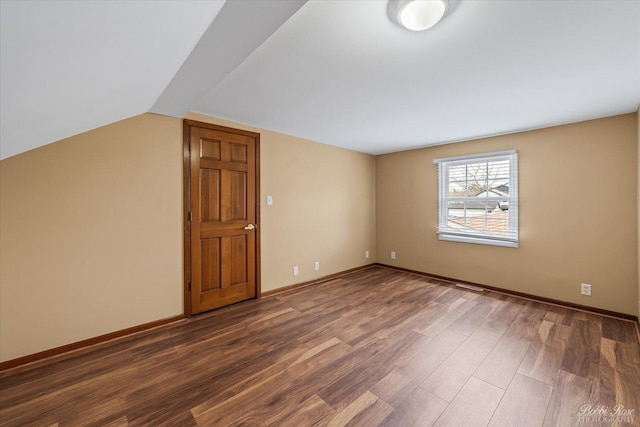 additional living space with vaulted ceiling, wood finished floors, and baseboards