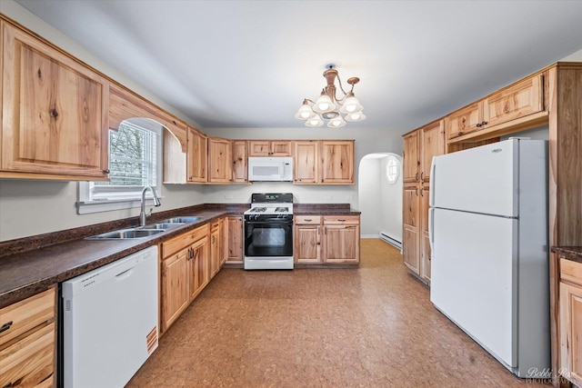 kitchen with a baseboard heating unit, dark countertops, white appliances, and a sink