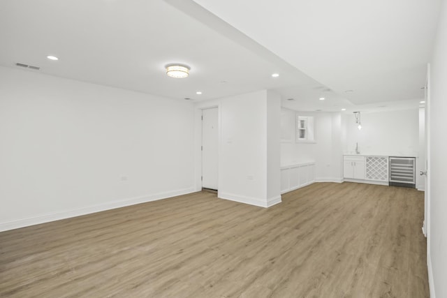 6460 S Kenwood Ave, Chicago, IL 60637 - unfurnished room featuring visible vents, baseboards, light wood-type flooring, recessed lighting, and wine cooler