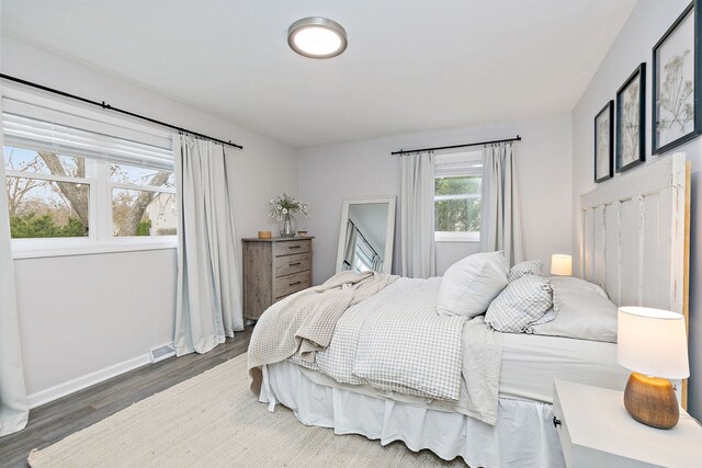 bedroom featuring wood finished floors, visible vents, and baseboards
