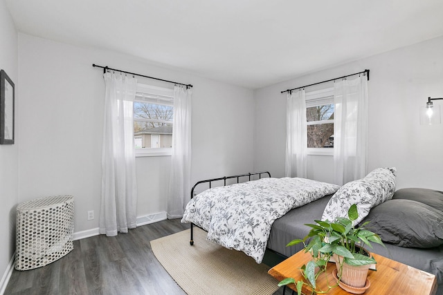 bedroom featuring baseboards, dark wood-style flooring, and multiple windows
