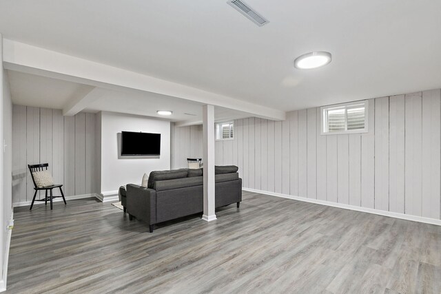 living area featuring beamed ceiling, wood finished floors, visible vents, and baseboards