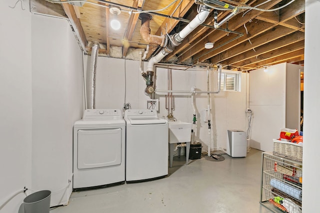 washroom featuring washing machine and dryer, a sink, and laundry area