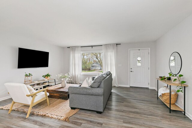 living area featuring baseboards and wood finished floors