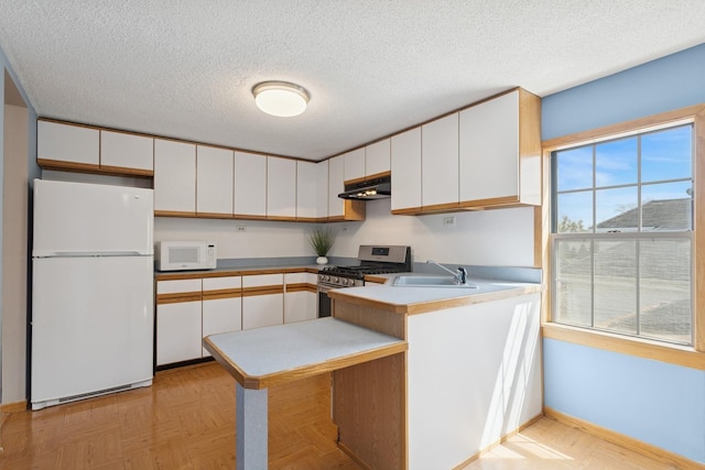 kitchen with a sink, white appliances, a peninsula, white cabinetry, and under cabinet range hood