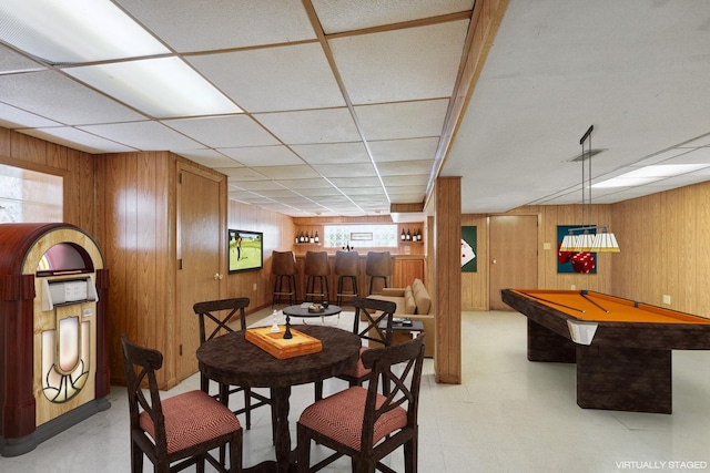 rec room with wooden walls, pool table, a paneled ceiling, and light floors